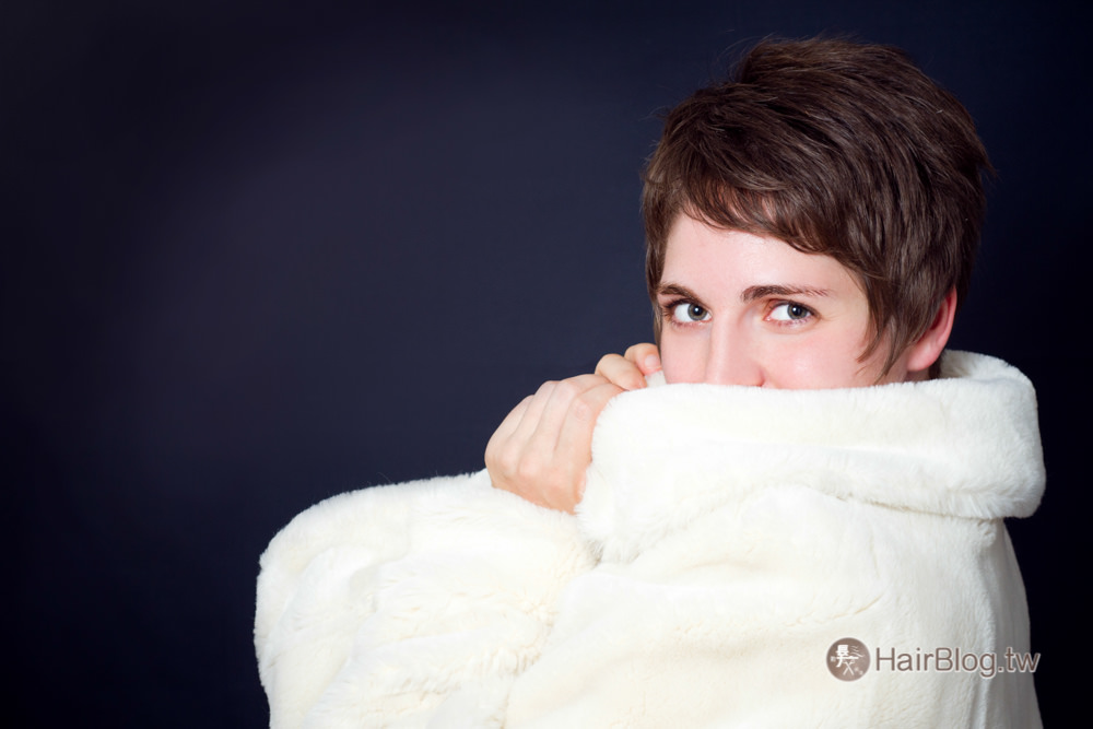 Beautiful young woman in a fur coat - dark background